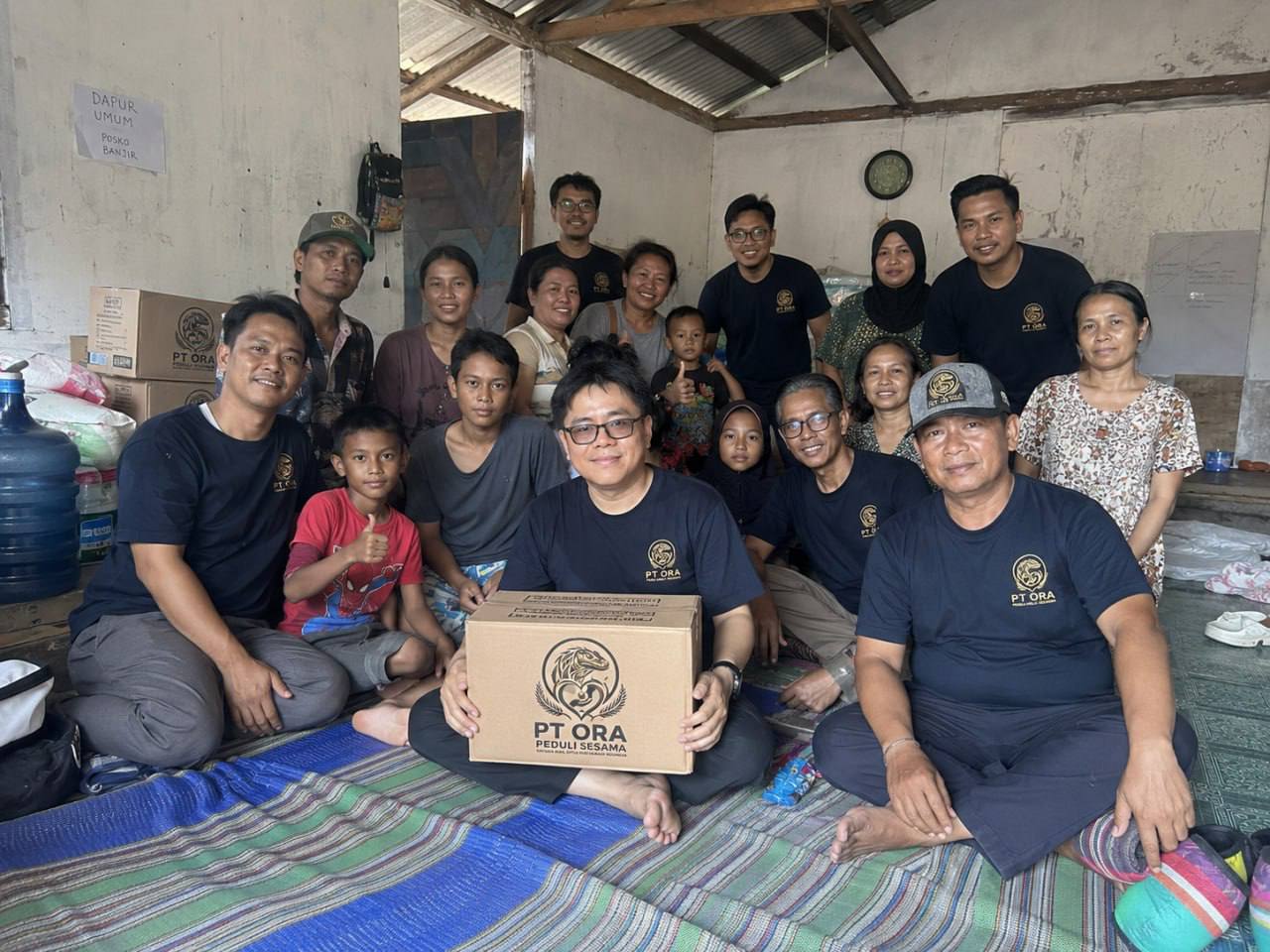 Kelompok bersama kotak bantuan di ruang dengan tanda dapur umum posko banjir